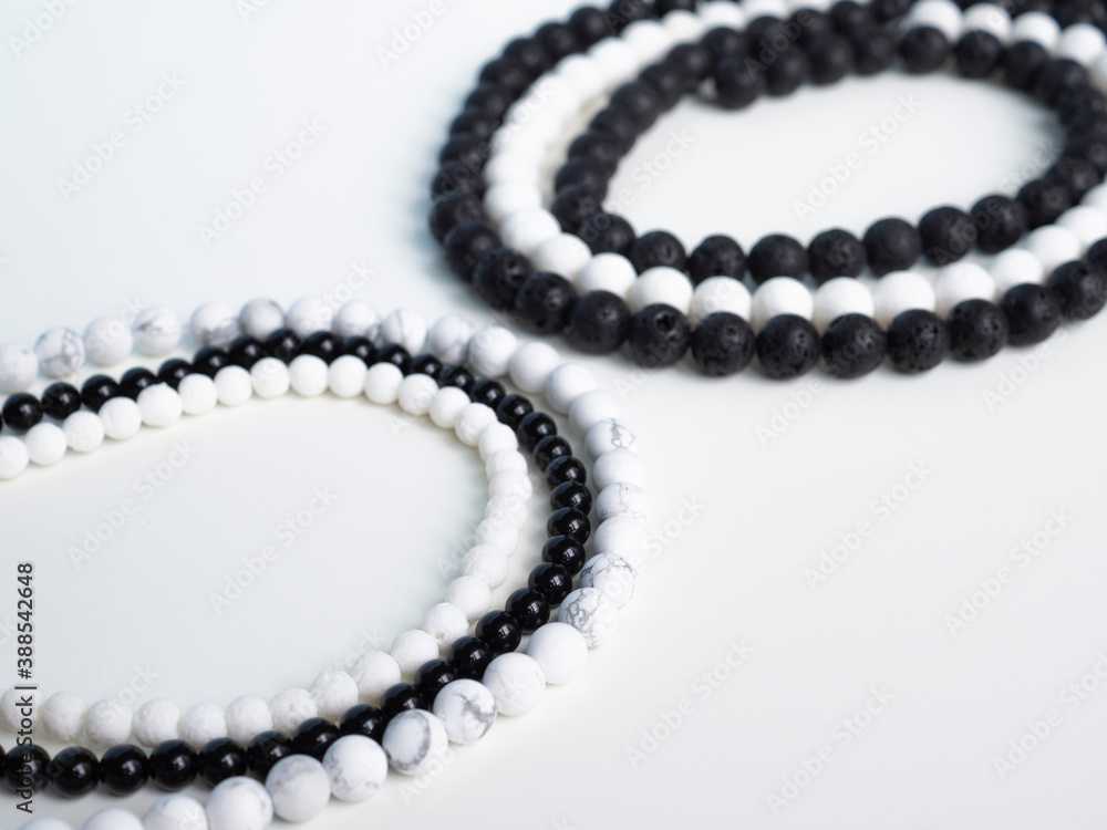 Beads from black lava stone and white coral on a white background