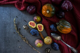 Fresh fruits and vegetables on a table: plums, grapes, pumpkin and figs.  Autumn mood still life. 