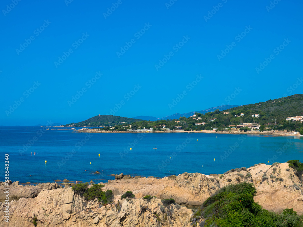 Felsige Küste und Sandstrand in der Balagne-Region von Korsika mit türkisfarbenem Mittelmeer und klarem blauem Himmel, Korsika Frankreich