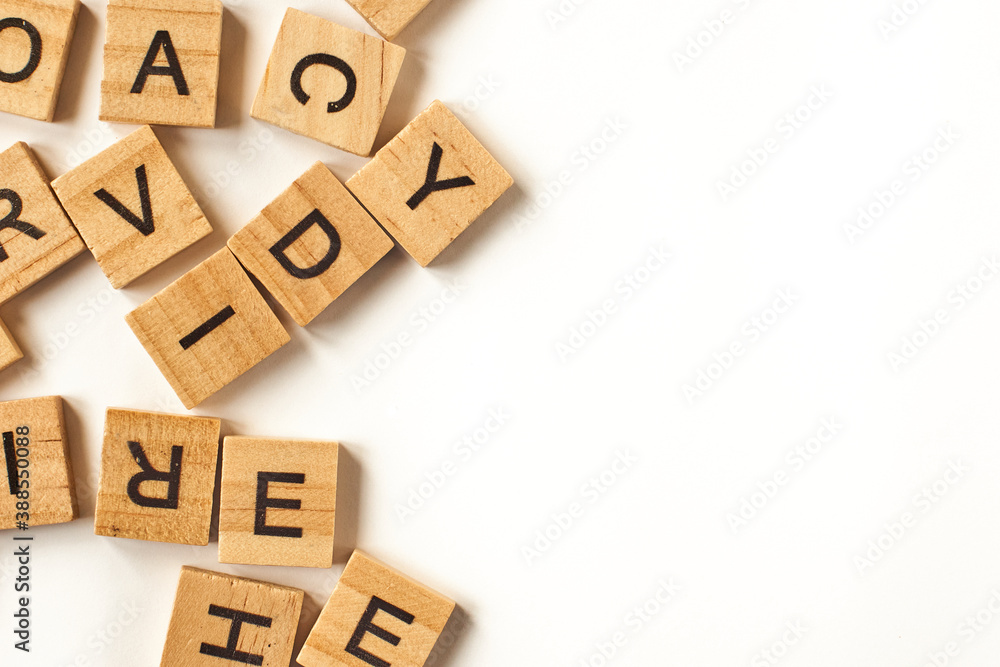 Top view of square wooden tiles with the English alphabet scattered on a white background with space for text. The concept of thinking development, grammar. Top view of square wooden tiles with the English alphabet scattered on a white background with space for text. The concept of thinking development, grammar.