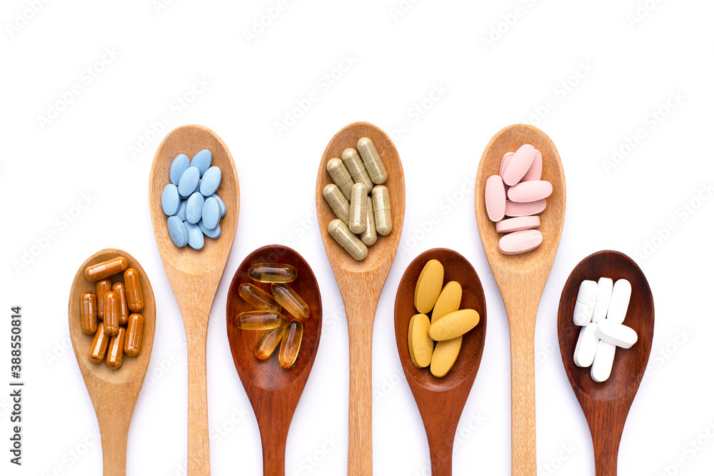 spoons with medicine tablets and capsules isolated on white spoons with medicine tablets and capsules isolated on white