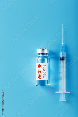 Medicines with syringe Vaccine ampoule on a blue background.