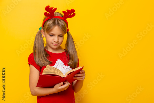 Little girl wearing antlers reading a book