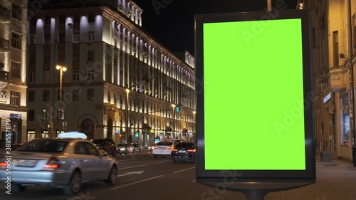Wallpaper Mural A green screen billboard located on the sidewalk on which people walk, next to a busy street. Cars move in the evening. 4K Torontodigital.ca