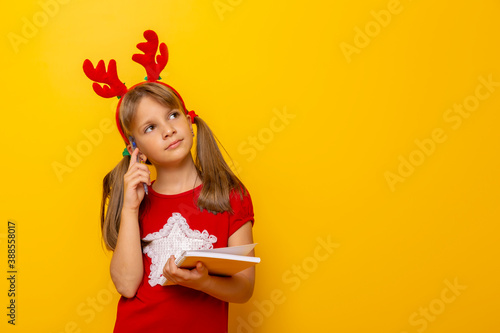 Little girl pensive while writing a letter to Santa