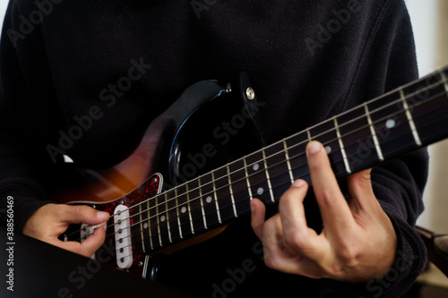 Obraz na płótnie Boy playing a beautiful electric guitar of various colours with his hands w salonie