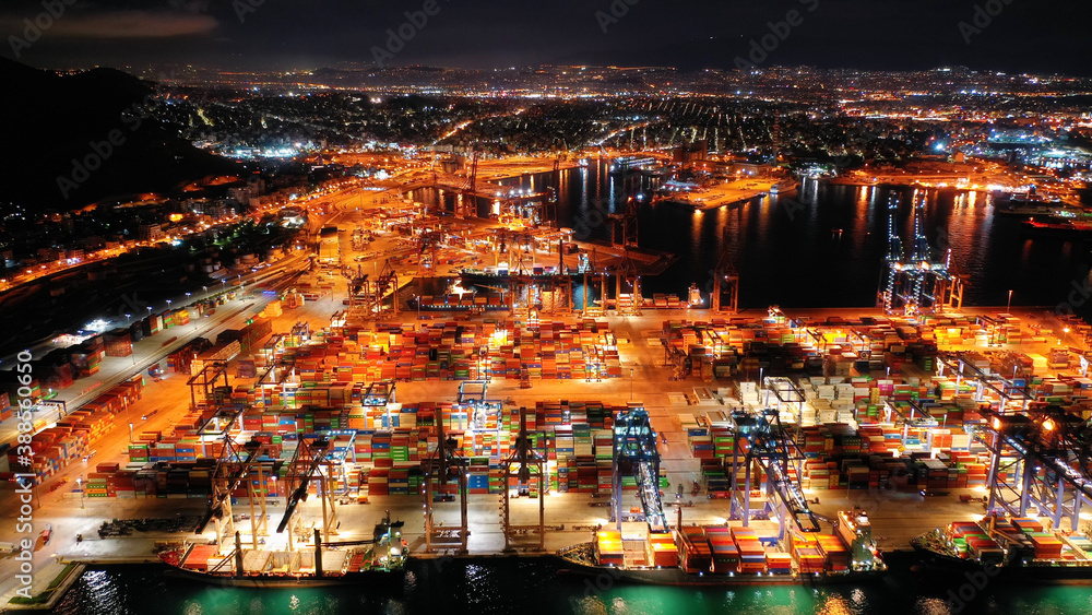 Aerial drone night shot of illuminated container terminal facilities in popular Mediterranean logistics port