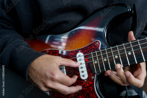 Photo Boy playing a beautiful electric guitar of various colours with his hands