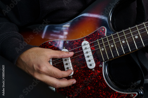 Photo Boy playing a beautiful electric guitar of various colours with his hands