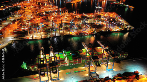 Aerial drone night shot of illuminated loading unloading container terminal in commercial port of Perama  Piraeus  Attica  Greece