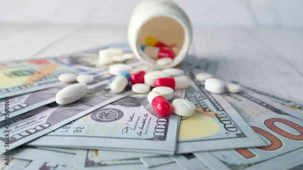 Healthcare cost concept with us dollar , container and pills on table Healthcare cost concept with us dollar , container and pills on table