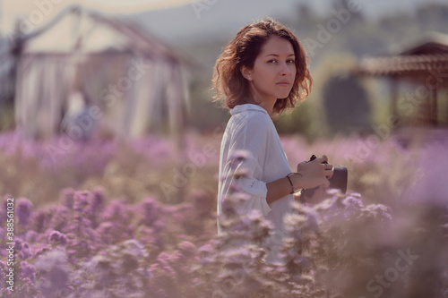 Obraz na płótnie young cute woman professional photographer on a flower field in summer w salonie