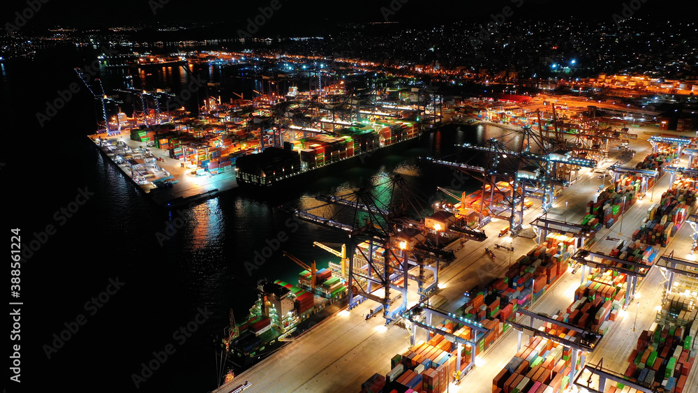 Aerial drone night shot of illuminated container terminal facilities in popular Mediterranean logistics port