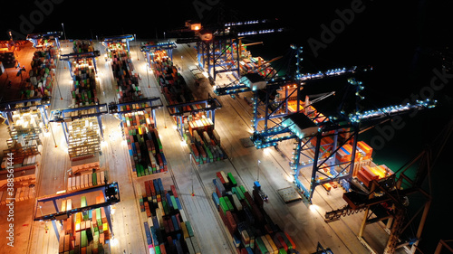 Aerial drone night shot of illuminated loading/unloading container terminal in commercial port of Perama, Piraeus, Attica, Greece