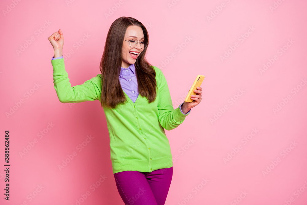 Photo of delighted girl use smartphone win raise fists scream wear shirt pants trousers isolated pastel color background Photo of delighted girl use smartphone win raise fists scream wear shirt pants trousers isolated pastel color background