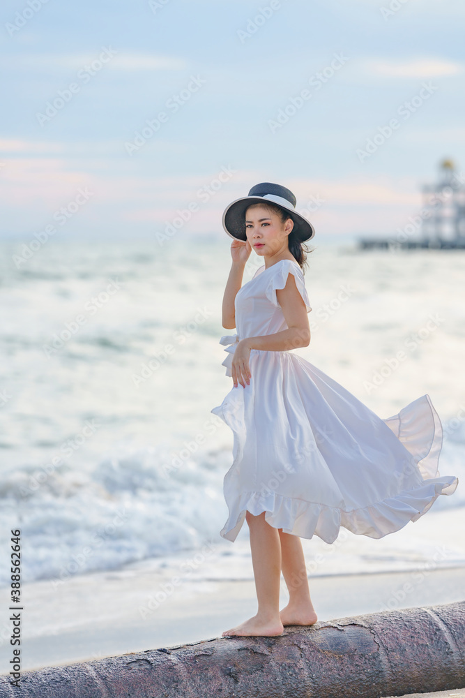Beautiful women in white dress happily strolling at the beach, beautiful women dressed in white bride
