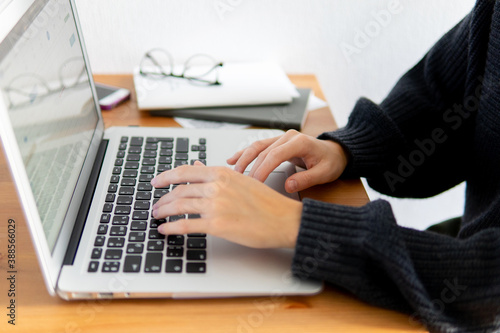 business composition. hands are typing the text behind the laptop. close-up of keyboard and hands