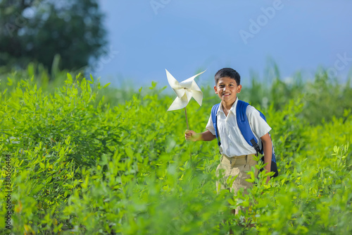 indian child running and playing with pinwheel