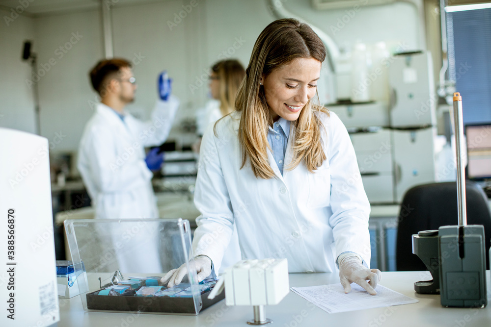 Female scientist in white lab coat standing in the biomedical lab Female scientist in white lab coat standing in the biomedical lab