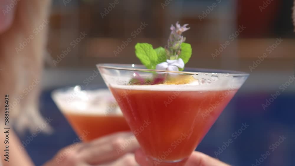Unrecognizable couple enjoying refreshing drinks lying on sunbeds on poolside Unrecognizable couple enjoying refreshing drinks lying on sunbeds on poolside
