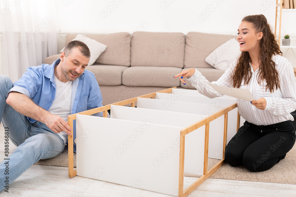 Happy Family Couple Installing Cabinet Shelf Together Furnishing New Home Happy Family Couple Installing Cabinet Shelf Together Furnishing New Home