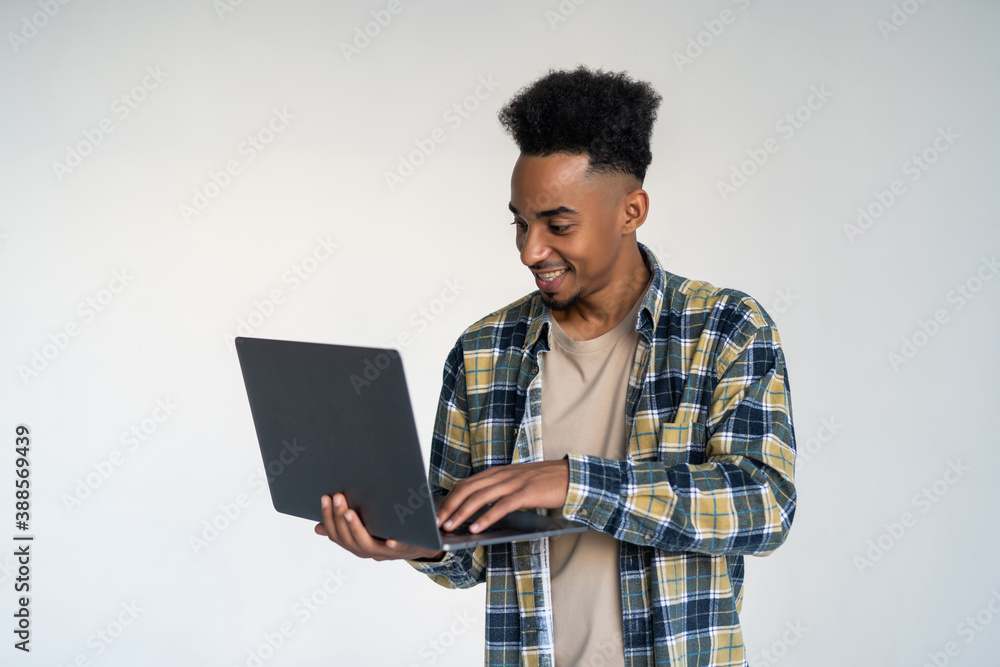 Young african american man using a laptop, isolated on white background Young african american man using a laptop, isolated on white background