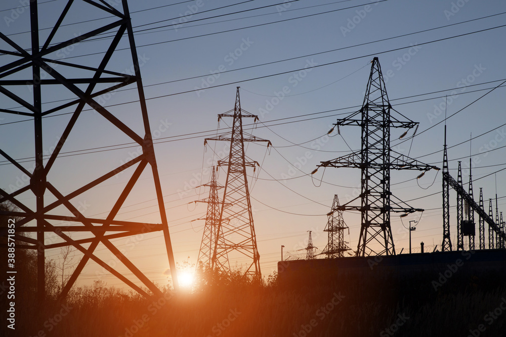 Electric powerlines on electric substation and distribution power. High voltage power lines, pylons at sunset Electric powerlines on electric substation and distribution power. High voltage power lines, pylons at sunset