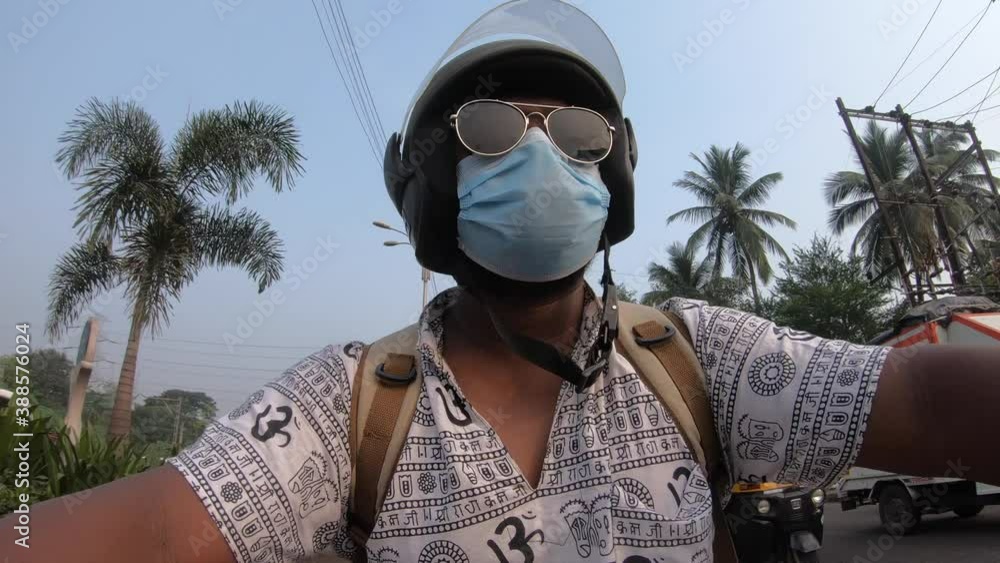 boy man with hippy shirt om print riding a bike in traffic with a mask on face goggles and helmet GoPro shot commercial boy man with hippy shirt om print riding a bike in traffic with a mask on face goggles and helmet GoPro shot commercial