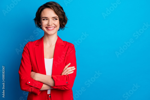 Portrait of attractive cheerful brown-haired lady folded arms looking aside copy space isolated on bright blue color background