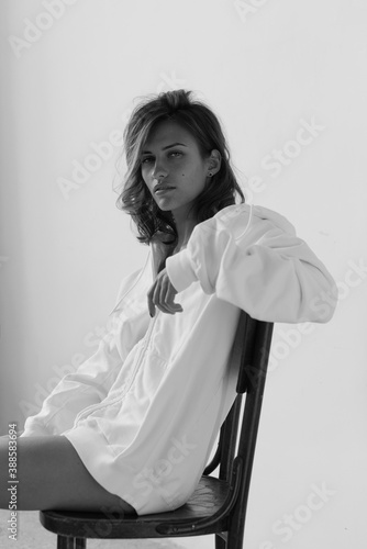 Portrait of beautiful young woman with brown hair and clean bronze skin without makeup on white background. Natural and healthy look. Neutral interior. Soft light. 