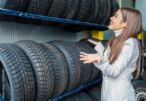Confused female choosing tires in the garage