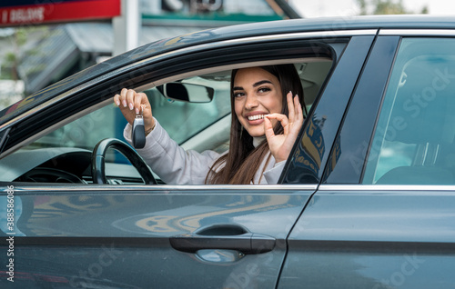 Young woman successfully passed a driving school test, happy face looking at camera