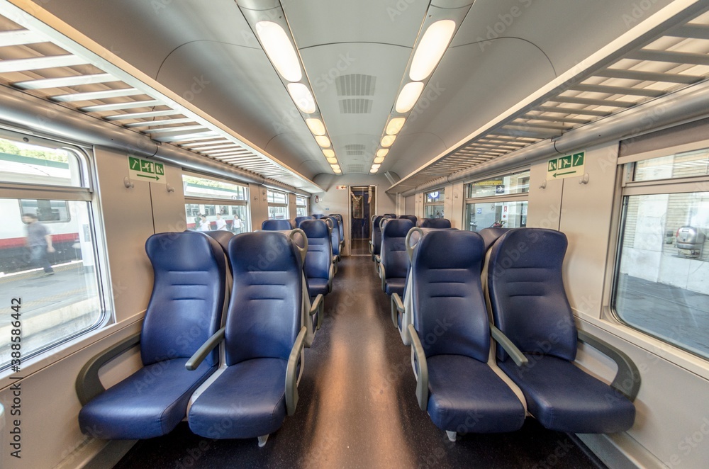 View of the interior of a train with empty seats View of the interior of a train with empty seats