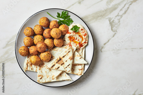 Falafels with hummus dip and flatbread on a plate