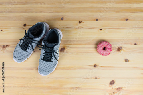 Grey sneakers, women's sports shoes for running, and pink strawberry doughnut on the side