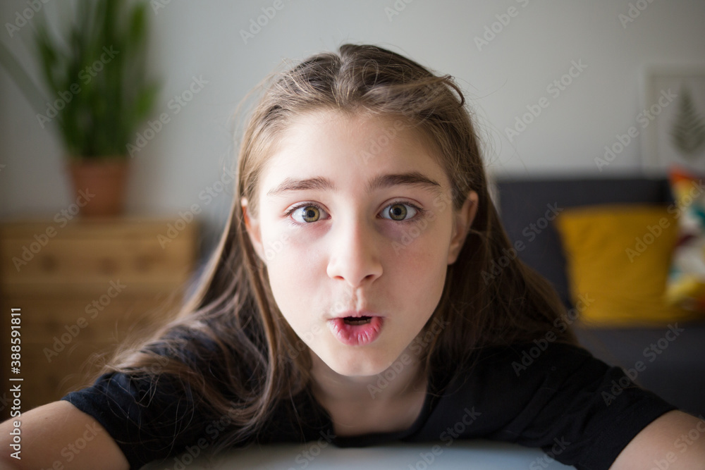 girl looks at camera and is surprised. student talks over Internet. Video Conference or e-learning at home. kids wonder and delight girl looks at camera and is surprised. student talks over Internet. Video Conference or e-learning at home. kids wonder and delight