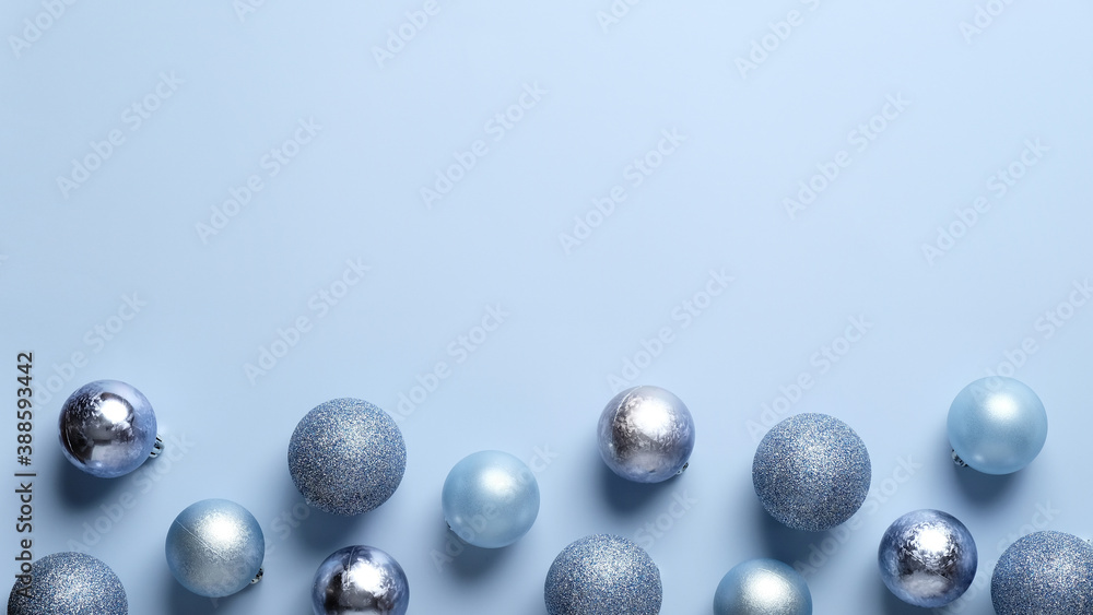 Christmas frame border made of blue and silver balls decoration on pastel blue background. Flat lay, top view. Christmas greeting card template, banner mockup.