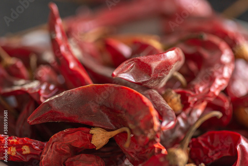 Dried red chili or chilli cayenne pepper on black marble background, close up photo