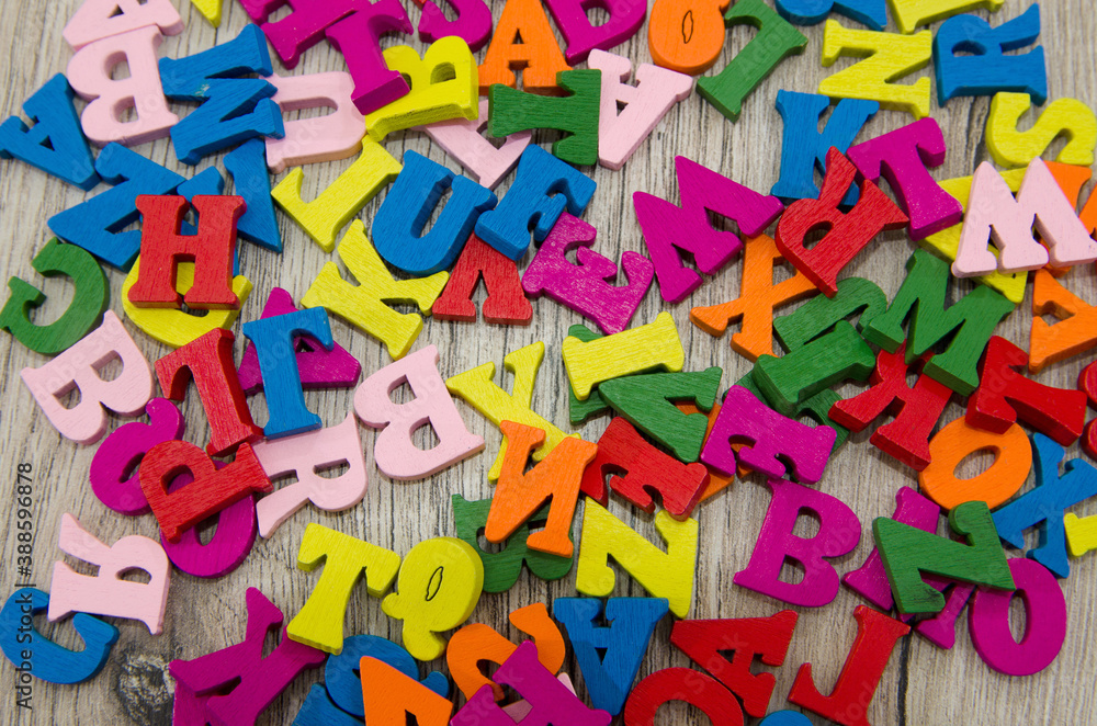 multicolored english letters on a wooden background. Alphabet. Background with colored letters. Learning concept