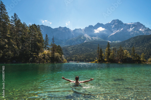 Man swimming in a beautiful mountain lake in the middle of the nature in the Bavarian Alps, Germany. Famous destination in Europe