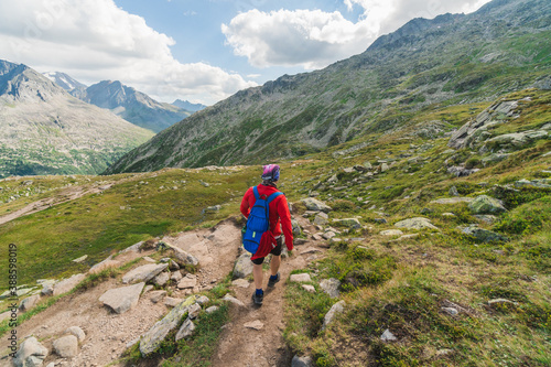 Young backpacker hiking a trail in the Alps mountains in Austria