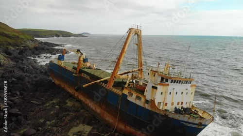 Old Shipswreck stranded on a rocky Beach. Abandoned Ghost Ship photo