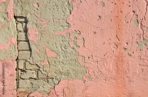 old brick wall with fragments of plaster and pink paint