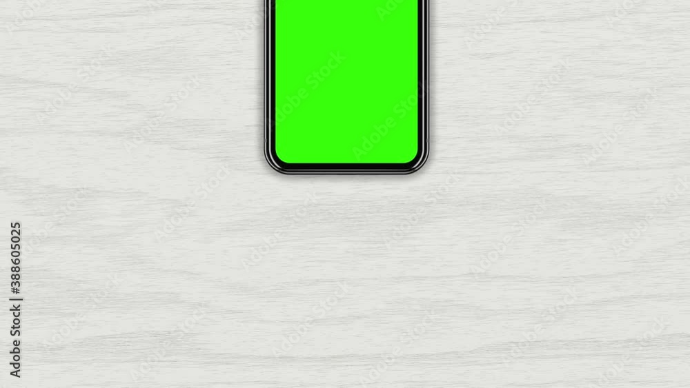 Top view, a smartphone with a green screen on a light wood table, a ...
