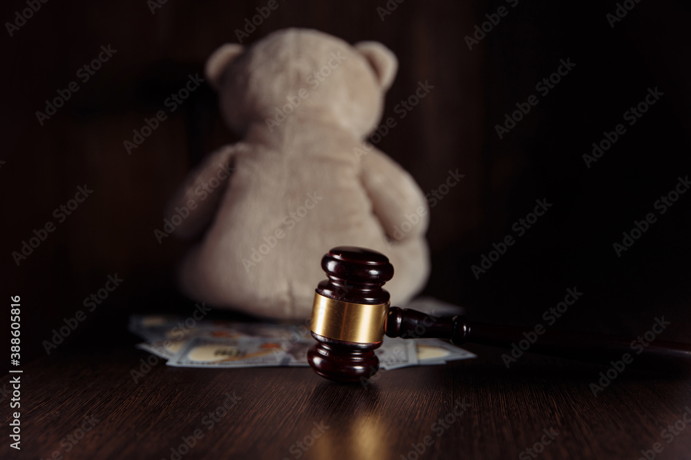 Dollar banknotes, judge gavel and teddy bear on a wooden table. Divorce and alimony concept. Dollar banknotes, judge gavel and teddy bear on a wooden table. Divorce and alimony concept.
