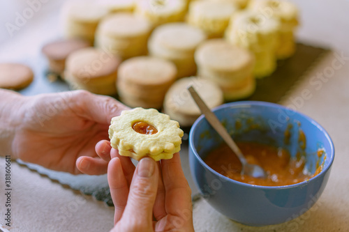 Grandma making traditional german spitzbuben weihnachtskekse linzer biscuit cookies filled with marmalade photo