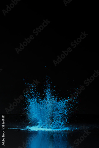 Blue holi powder explosion on black, traditional Indian festival of colours