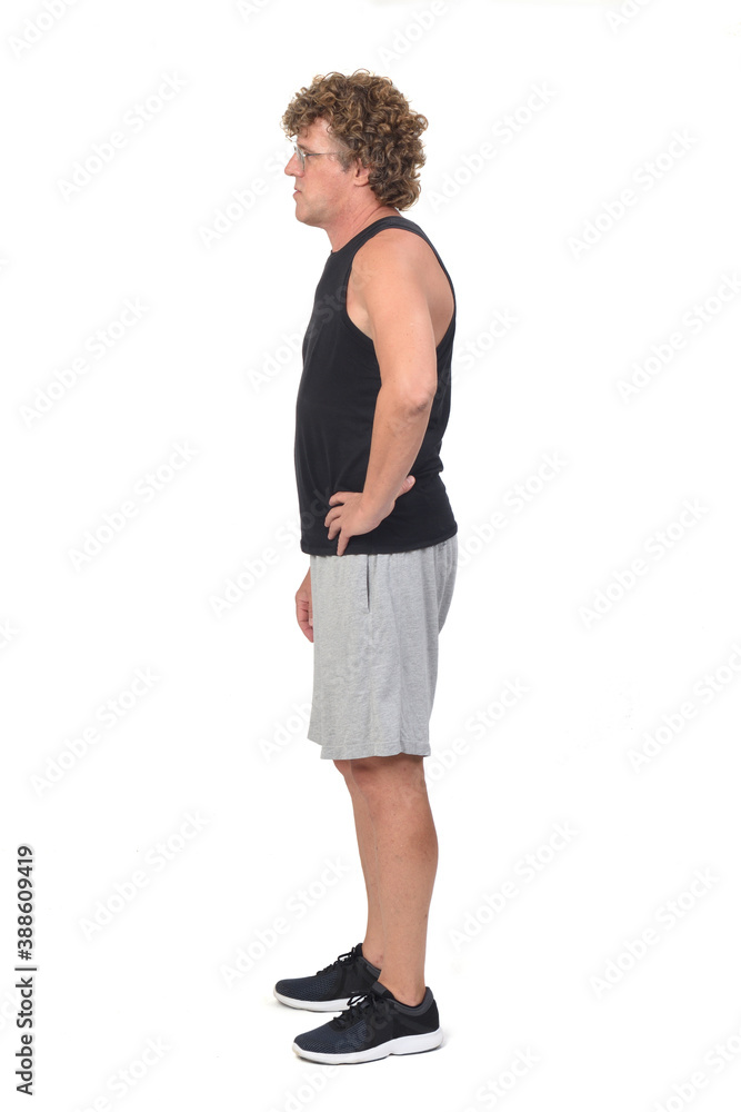 side view of a man wearing sportswear tank tops and shorts on white background, hand on hip side view of a man wearing sportswear tank tops and shorts on white background, hand on hip