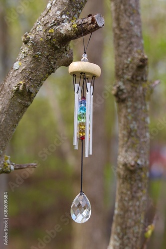 wind chime with chakra stones hangs from tree