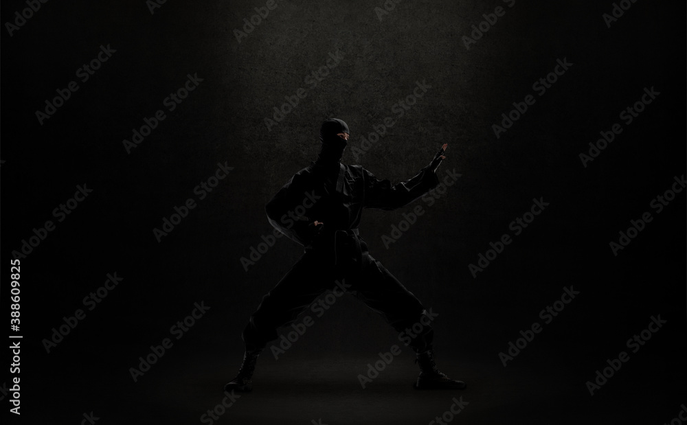 japanese ninja in black uniform on black background